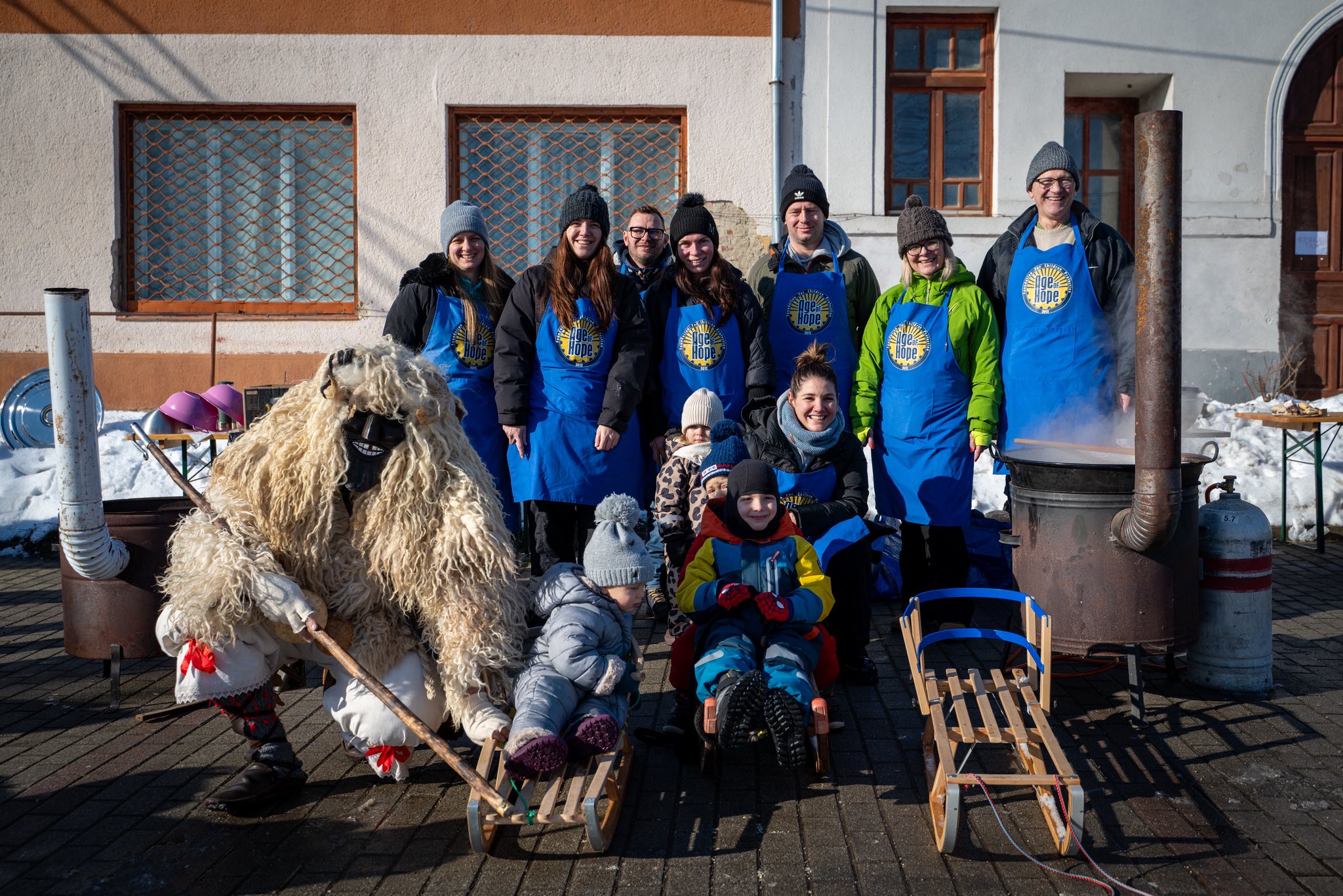 Volunteers in Age of Hope aprons around the cauldron
